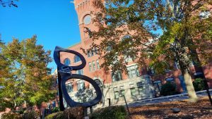 large brick building with glasses statue